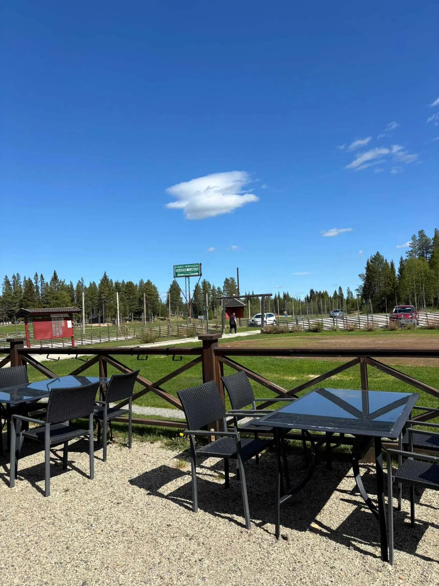 Uteserveringen med bord och stolar och utsikt mot golfbanan